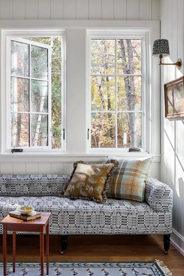 Soft linen window seat nook from @katierosenfeld. Cozy space with serene forest views and cottagecore living room charm.