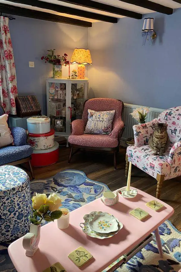 Vibrant mixed floral prints on cozy cushions from @emmys_vintage_cottage. Bold patterns brighten a cottagecore living room.