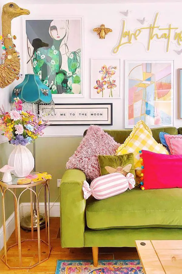 Colorful gallery wall and plush pillows from @lillyswatercolours. Whimsical cottagecore living room charm.