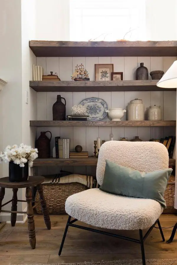 Rustic wooden open shelving from @house_of_7feathers. Charming display of vintage treasures in a cozy cottagecore living room.