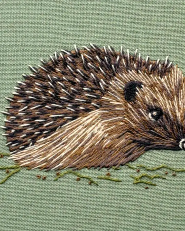 Detailed thread painting hedgehog embroidery from @cosycraftclub on sage green linen with textured spines