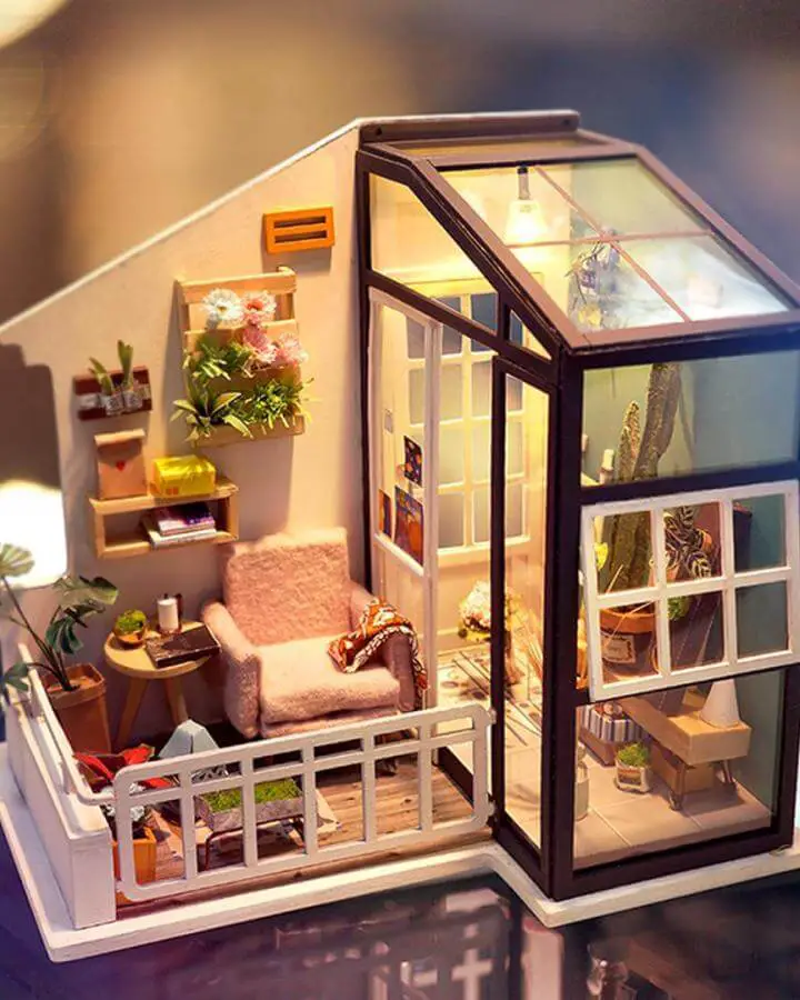 Miniature greenhouse with wooden frames from @handscraftus featuring craft ideas for adults with glass panels and pink furniture.