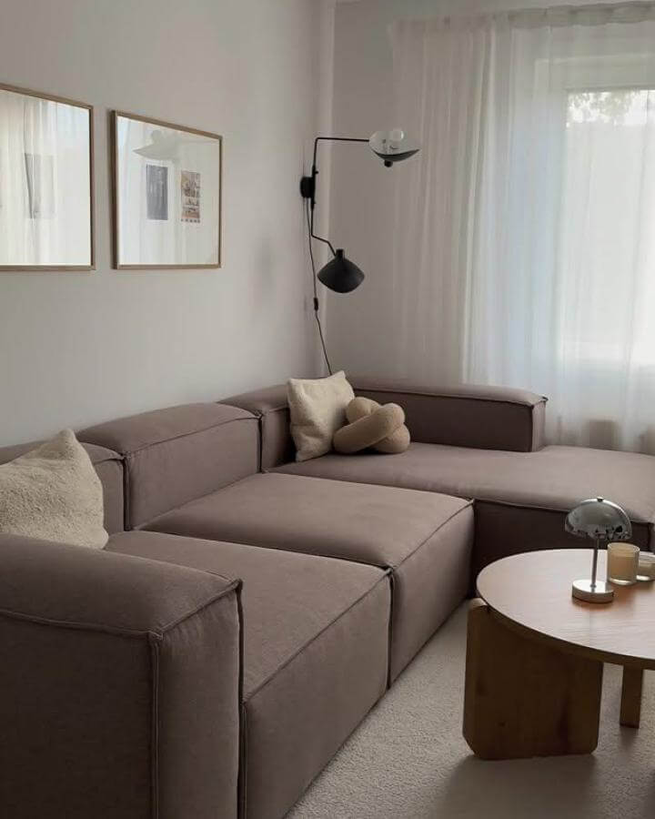 Dark brown modular couch with soft beige cushions and light wood coffee table in a bright, minimalist living room from @melekoer