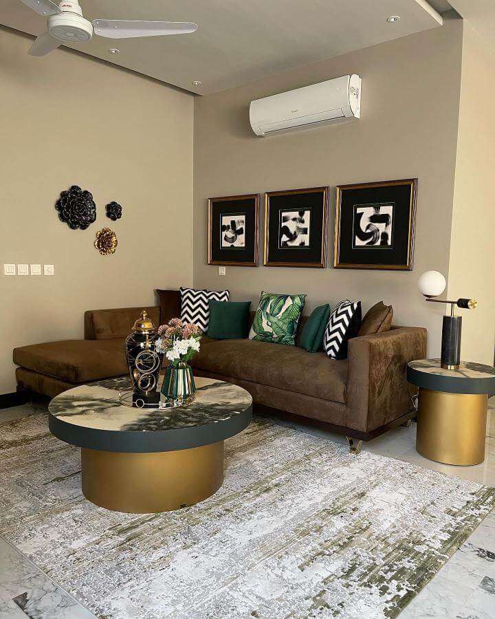 Dark brown suede couch with bold patterned cushions and green accents in stylish living room from @thenativehomeofficial dark brown couch living room ideas.