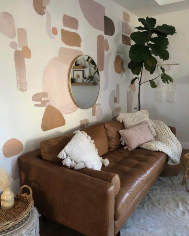 Caramel leather sofa with knitted pillows and blush cream accents in comfy living room by @lifestylenthings.