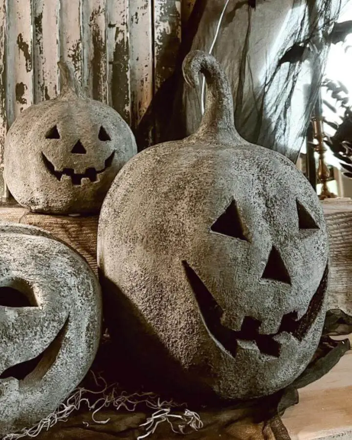 Stone textured jack-o'-lanterns from @shady_pines3interiors showcasing dark fall decor ideas with weathered gray finish and spooky carved faces.