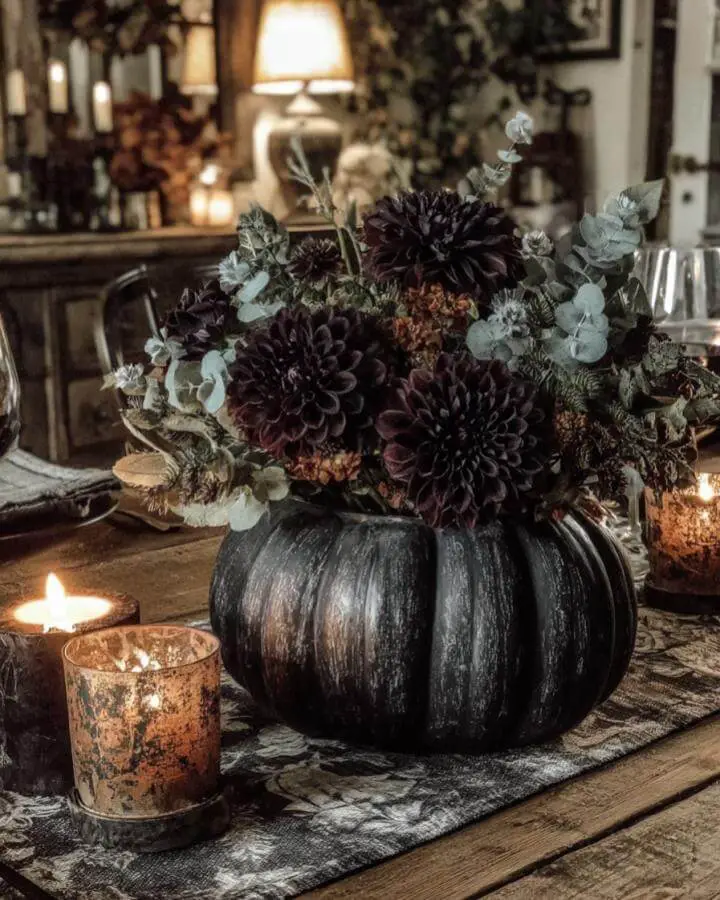 Black pumpkin centerpiece filled with burgundy flowers and eucalyptus showcasing elegant dark fall decor ideas perfectly.