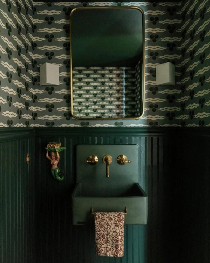 dark green powder room with patterned wallpaper, brass fixtures, and vintage sink from @chrismottalini creating cozy charm