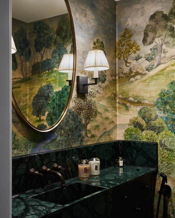 dark green powder room with emerald marble vanity and scenic mural wallpaper by @ursulaarmstrong creating a cozy, nature-inspired vibe