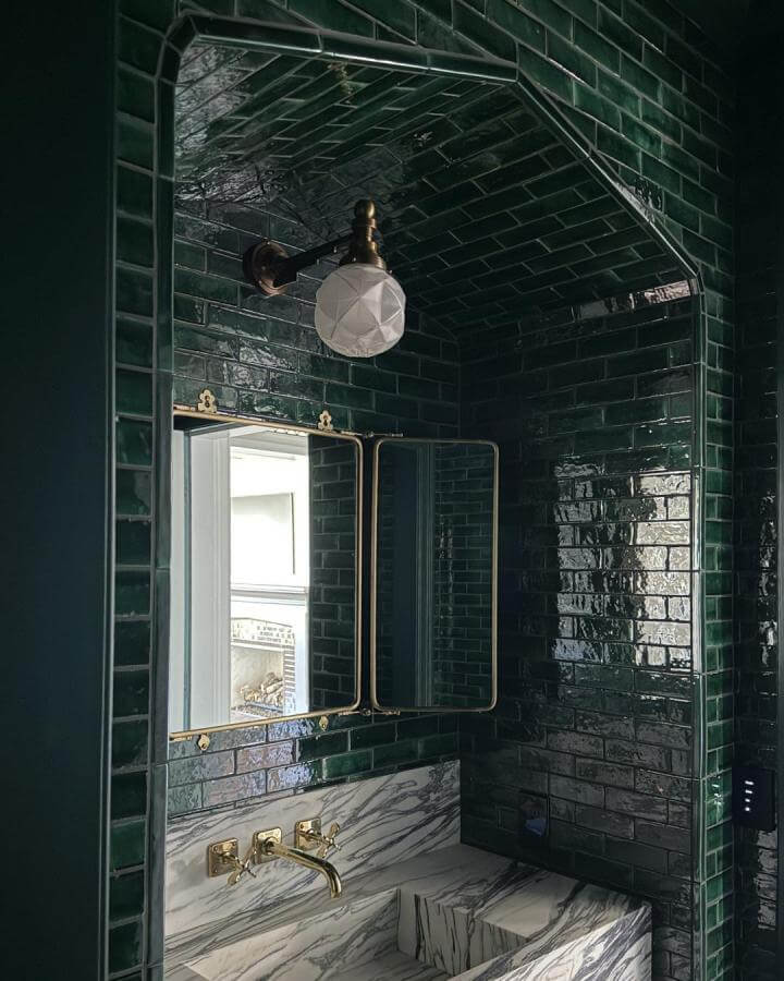 dark green powder room with glossy subway tiles brass fixtures and marble sink from @lisastatondesign creating a moody elegant vibe