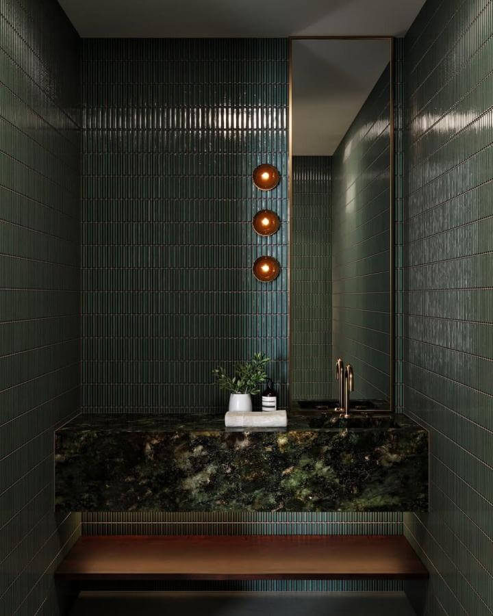 dark green powder room with textured tiles and floating green marble vanity from @bb.renderstudio illuminated by warm wall sconces and under-shelf lighting