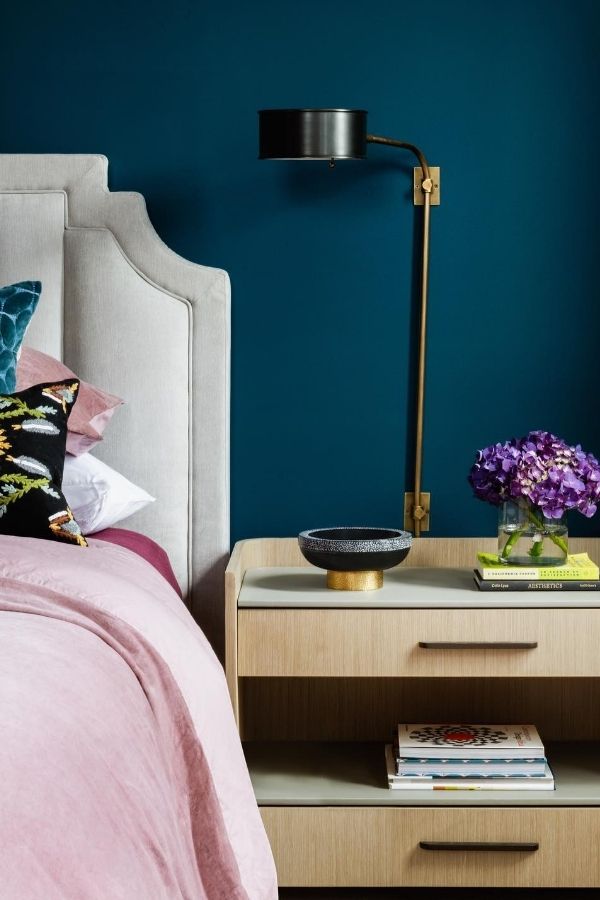 Elegant teal armchair surrounded by pastel artwork, creating a cozy ambiance.