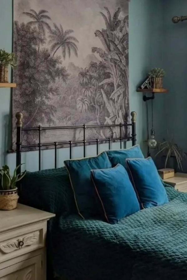 Vintage bedroom with teal accents, jungle-themed decor, and botanical prints.