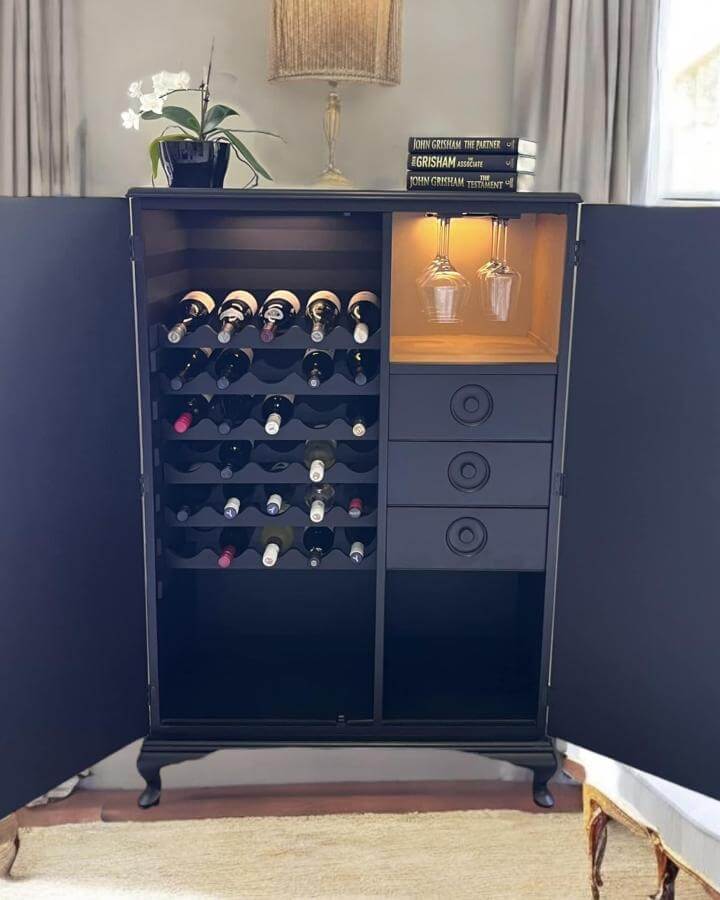 Black upcycled wardrobe drinks cabinet from Ballerina with a Paintbrush featuring built-in bottle racks and illuminated glassware nook diy drinks cabinet ideas.