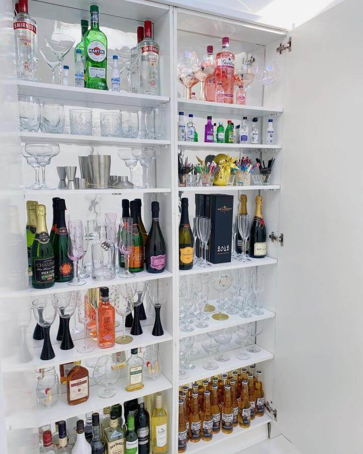 Bright white IKEA drinks cabinet showcasing bottles and glassware by @fenloninteriors with neat, clean diy drinks cabinet ideas. Organized and stylish.
