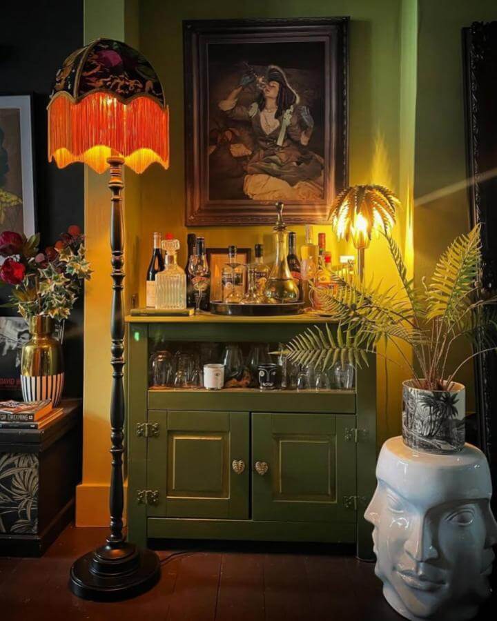 Olive green upcycled vintage drinks cabinet with heart-shaped knobs and brass hinges styled by @violetmayhome for diy drinks cabinet ideas in cozy room.