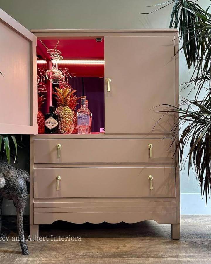 Blush pink vintage Harris Lebus cabinet with brass tassel pulls and bright raspberry red interior by @percy_and_albert for diy drinks cabinet ideas. Classic turned modern.