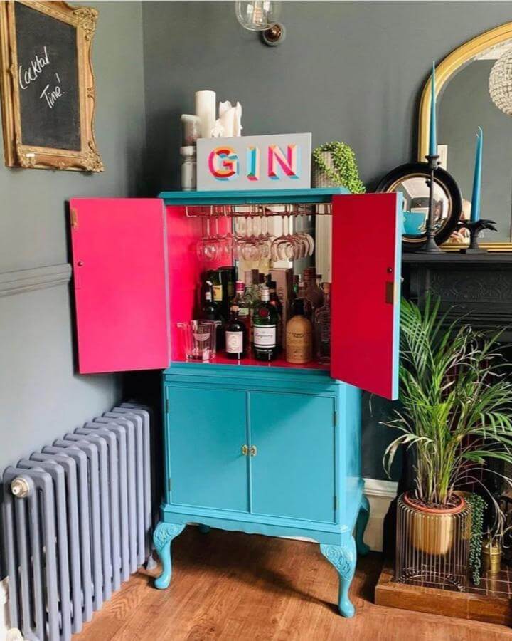 Vibrant turquoise and hot pink DIY drinks cabinet ideas with glass racks from @mycolourfulupcycle in stylish home setting.