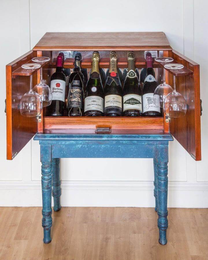 Antique wooden luggage rack style diy drinks cabinet ideas with blue distressed legs and glass holders from @uniquefurnitureedinburgh.