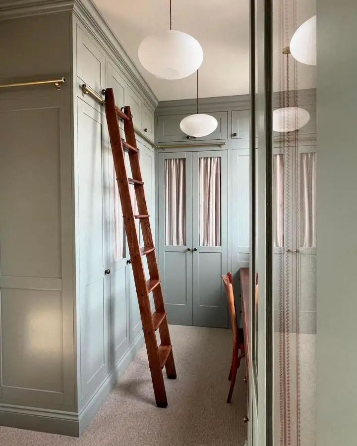 Sage green closet with wooden ladder from @thepureedit showcasing perfect dream dressing room ideas.