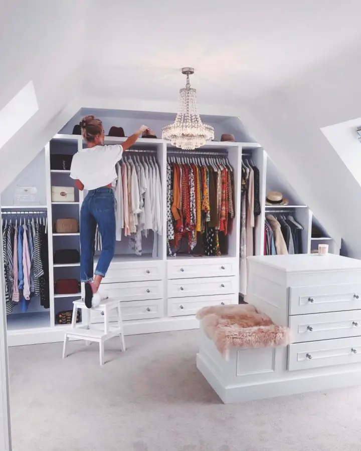 White built-in closet system from @kristyjgreen. Slanted ceiling maximizes attic space with crystal chandelier centerpiece.