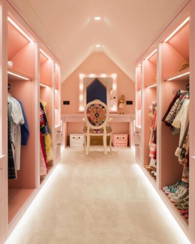 Pink walk-in closet from @doigfurniture. Hollywood vanity mirror with illuminated bulbs and organized storage sections.