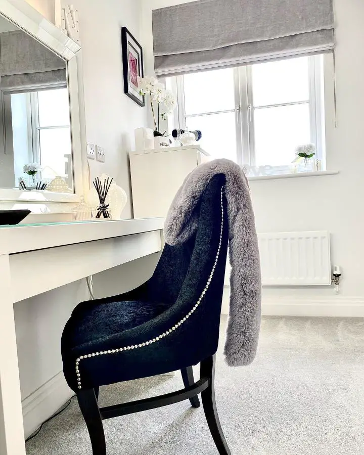 Navy velvet vanity chair from @dreamsandtravelss showcasing luxurious dream dressing room ideas with pearl stud detailing and gray fur throw.