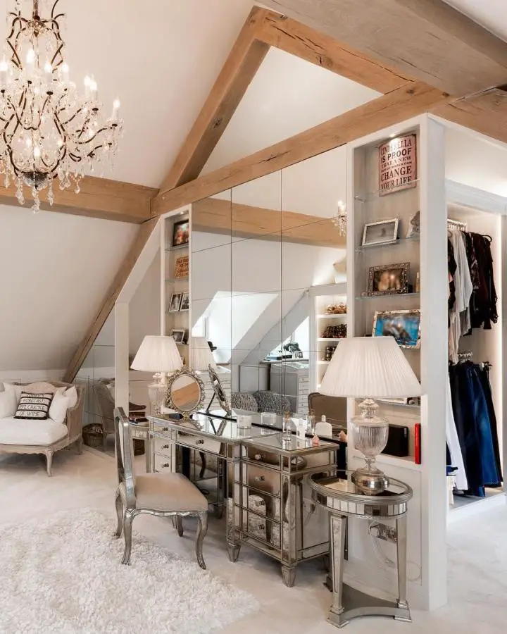 Rustic attic dressing room from @johnevansinteriordesign featuring exposed wooden beams and mirrored vanity furniture.