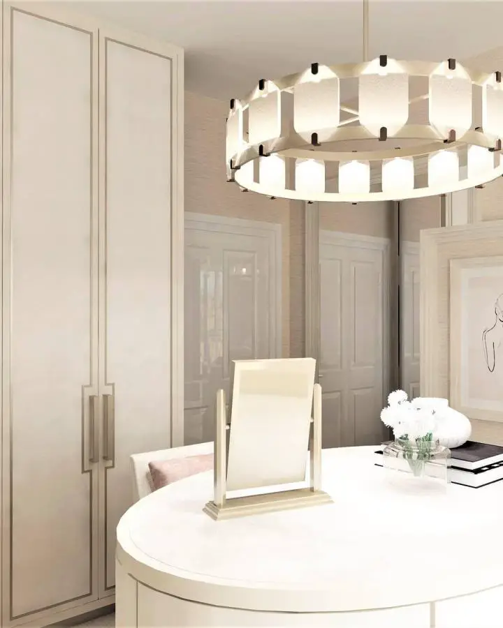Modern circular vanity table from @maryannegallodesign. Features geometric chandelier and neutral tones throughout space.