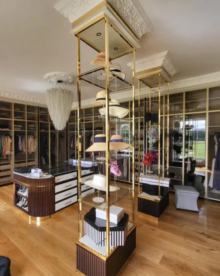Brass-framed display towers from @heibespoke. Boutique-style shelving units showcase accessories and shoes in luxury closet space.