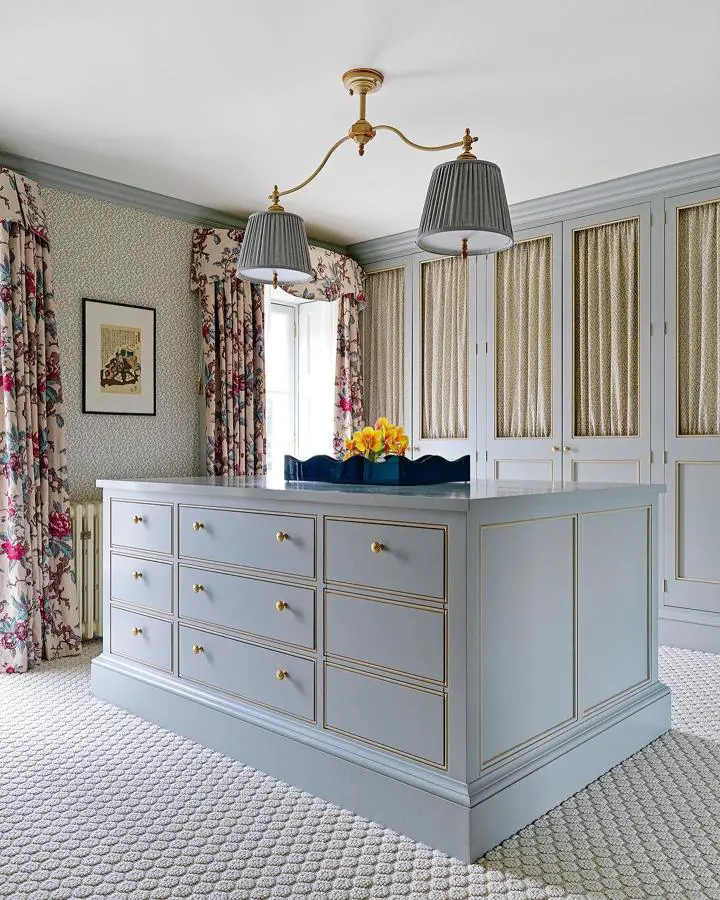 Sage green dresser island from @salvesengraham. Multiple drawers with brass hardware provide organized storage solutions.
