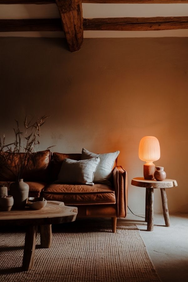 Earthy living room with warm tones, wooden furniture, and greenery.