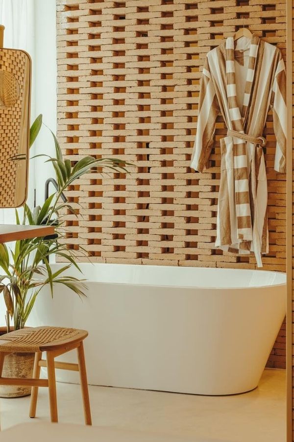 Stylish spa bathroom with textured brick wall and serene ambiance.