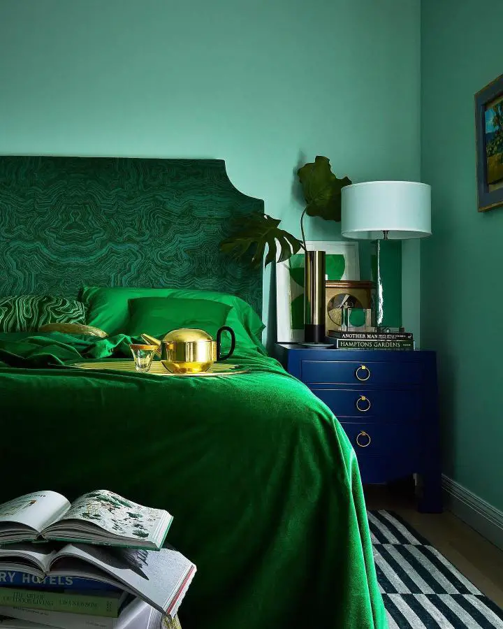 Dramatic malachite-patterned headboard from @1stdibs. Rich emerald bedding complements the swirling dark green upholstery design.