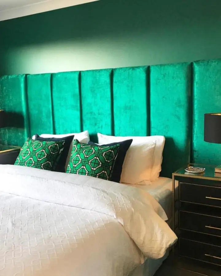 Emerald velvet paneled headboard from @buyingblind showcasing bold emerald green bedroom ideas with textured wall design.