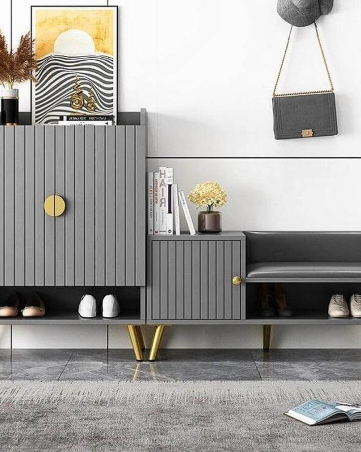 Gray modular shoe cabinet with gold knobs and legs in modern entryway by @fluent_decor. Stylish shoe storage with sleek design.
