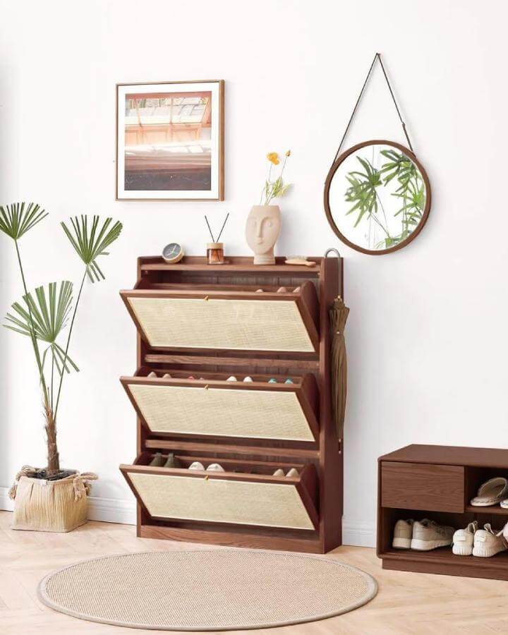 Brown wooden grapple shoe cabinet with woven fronts in a minimal entryway by @ramgarhcrafts featuring natural materials and neat entryway shoe storage ideas.