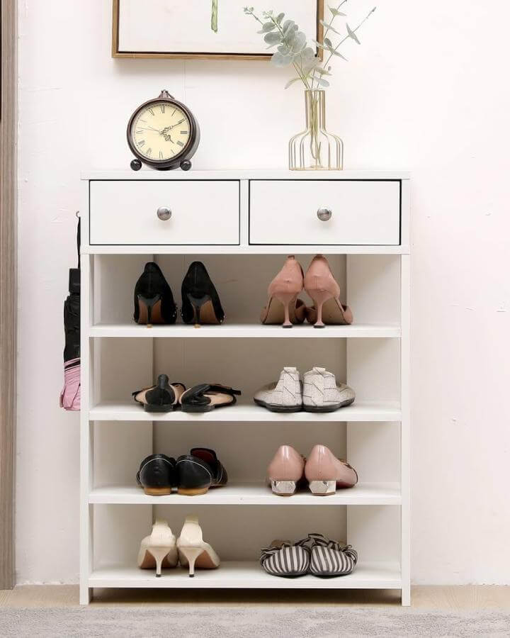 White wooden shoe rack with drawers in a minimal entryway holding various shoes from @ecoshopusa practical and neat storage solution