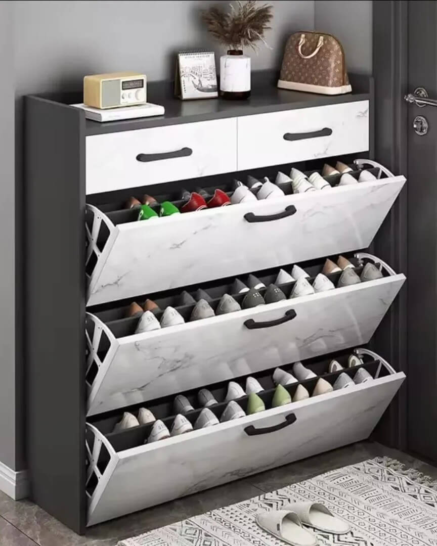 White marble-effect flip shoe rack with black handles in entryway shoe storage ideas by @blossoms_household_essentials. Compact and stylish shoe organization.