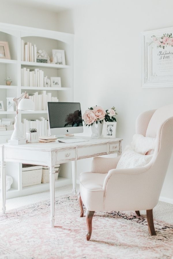 Feminine home office with pastel decor, cozy chair, floral accents, organized.