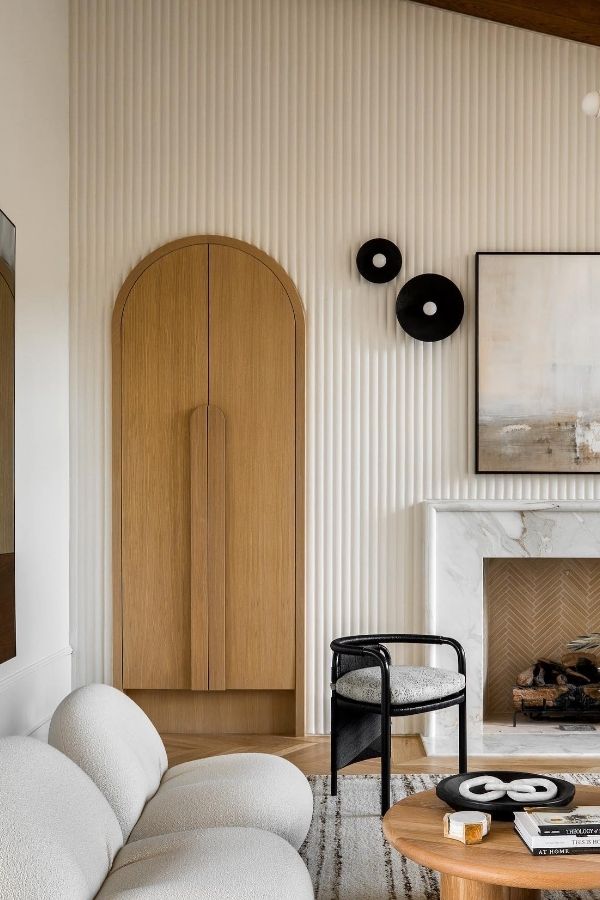 Chic living room featuring white fluting, plush seating, and decor.