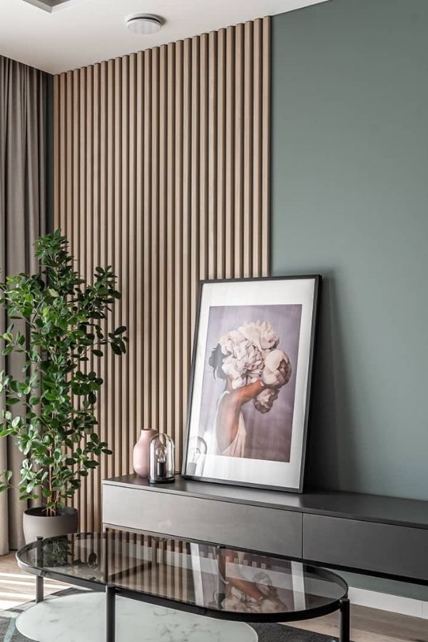 Living room with sleek green wall panels and modern decor.