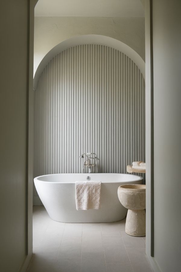 Modern bathroom featuring a fluted accent wall and archway design.