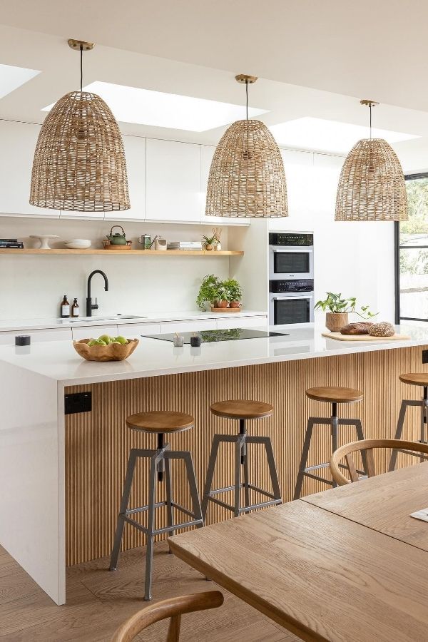 Sleek modern kitchen featuring stylish, fluted island panel, marble countertops.