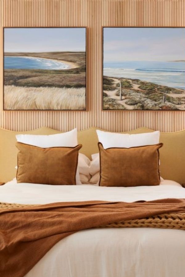 Seaside-themed artwork displayed above a textured fluted headboard design.