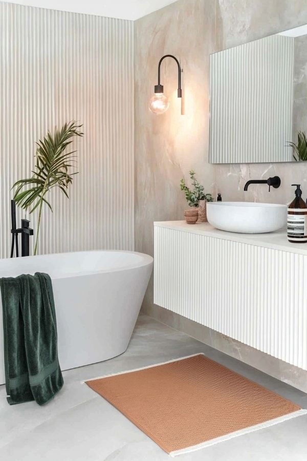 Bright, modern bathroom featuring white fluted wall and sleek fixtures.