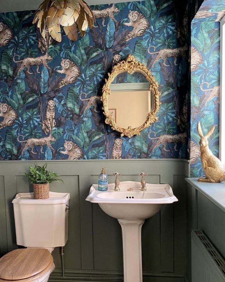 Jungle print wallpaper and vintage gold mirror create funky bathroom ideas with bold leafy greens by @reloving_my_home. Wild and lush decor.