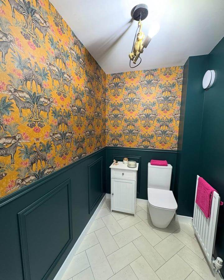 Mustard yellow jungle wallpaper and deep teal walls in small bathroom from @ournewbuild_thewilliams featuring brass monkey light and white fixtures funky bathroom ideas
