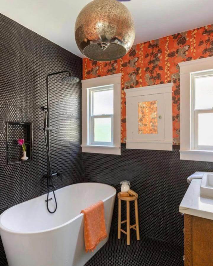 Black penny tile bathroom with orange retro wallpaper and copper light from @miltonandking showing funky bathroom ideas with bold contrasts and textures