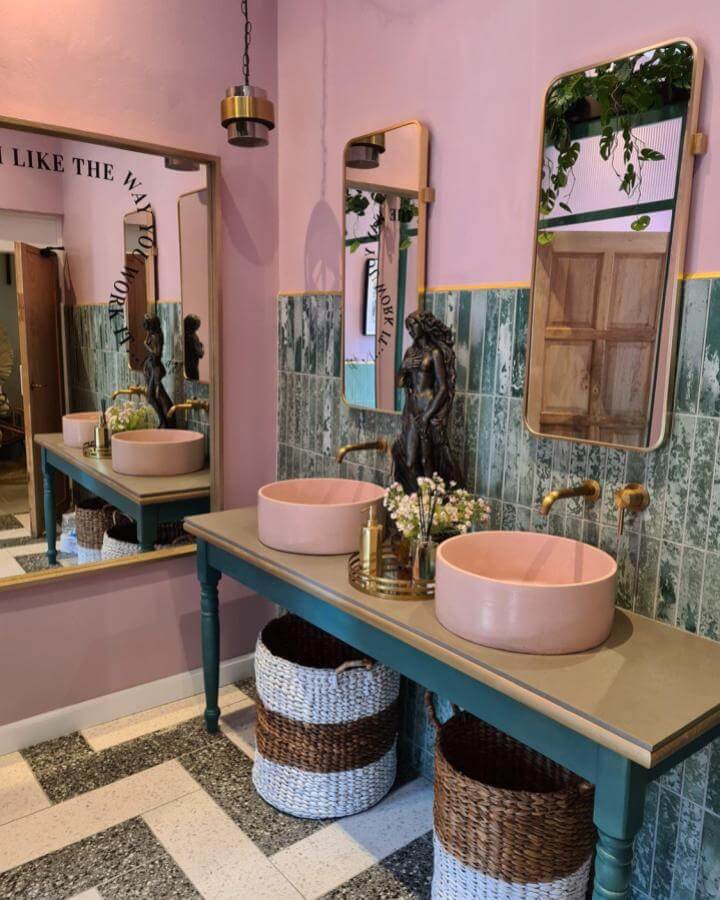 Pink sinks and green vintage tiles create funky bathroom ideas with brass accents and woven basket storage by @lux_crete. Stylish and bold.